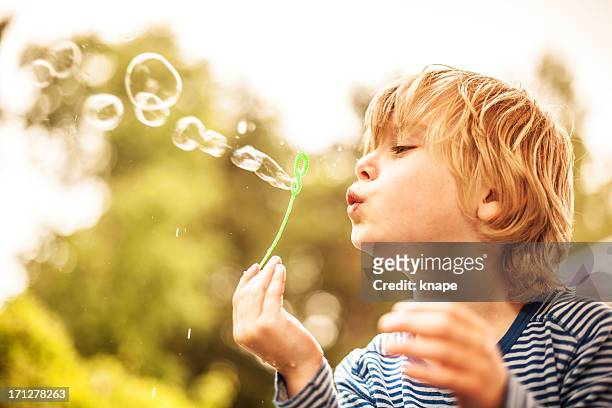 carino piccolo ragazzo all'aperto, soffiare bolle - bubble wand foto e immagini stock