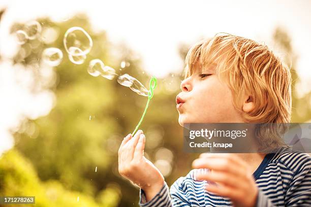 cute little boy outdoors blowing bubbles - blonde boy stock pictures, royalty-free photos & images