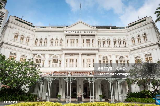 singapore raffles hotel doorman hailing taxi - raffles hotel stockfoto's en -beelden