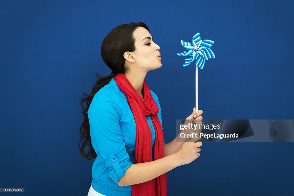 Young girl blowing a blue pinwheel