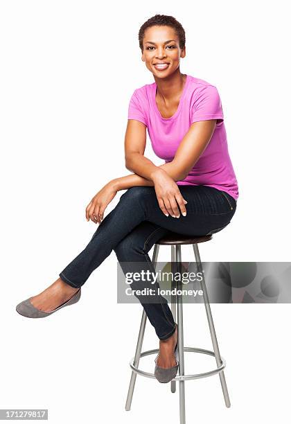 sonriente mujer afroamericana sentado en silla-aislado - con las piernas cruzadas fotografías e imágenes de stock