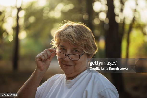 portrait of cheerful senior woman confidently looking at camera over eyeglasses - sourire narquois photos et images de collection