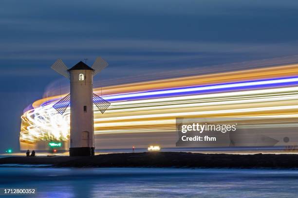 beacon at baltic sea with passing boat (long exposure) - wind turbine long exposure stock-fotos und bilder
