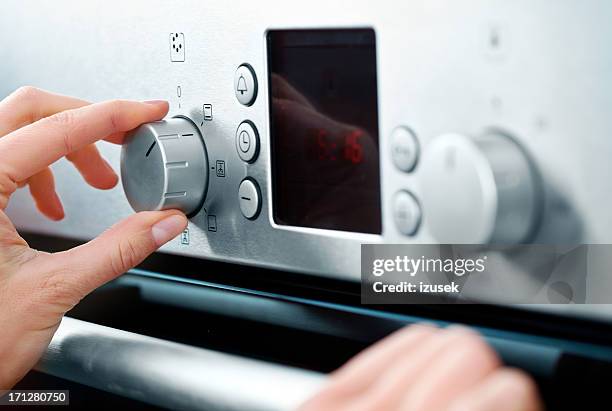 woman using baking-oven - hand adjusting stock pictures, royalty-free photos & images