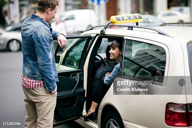 young couple entering the taxi cab - taxi stock pictures, royalty-free photos & images