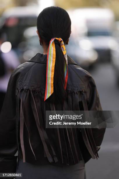 Mer is seen outside Hermes show wearing black Saint Laurent sunnies, Hermes silk scarf in her hair, brown cropped leather jacket, grey oversized suit...