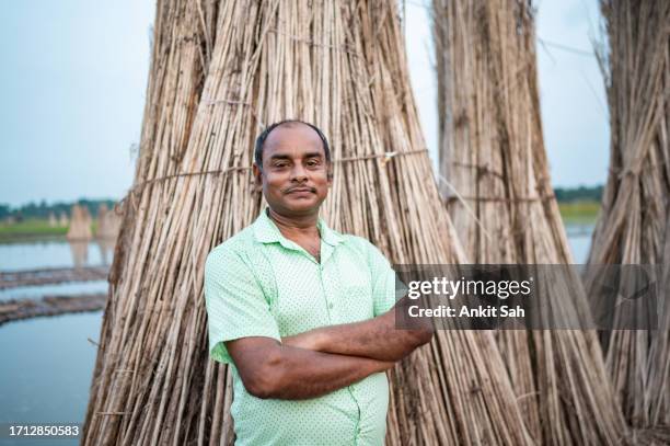 portrait of mid- adult indian farmer with arms crossed in agriculture field - farmer arms crossed stock pictures, royalty-free photos & images