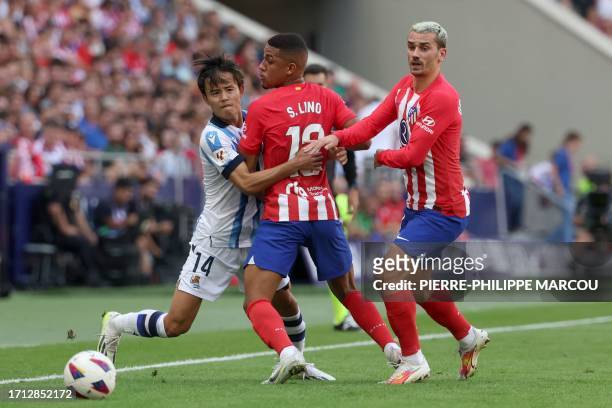 Real Sociedad's Japanese forward Takefusa Kubo vies with Atletico Madrid's Brazilian forward Samuel Lino and Atletico Madrid's French forward Antoine...