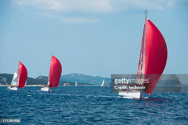 sailboats with red genackers compeeting during regatta - championship day three stockfoto's en -beelden