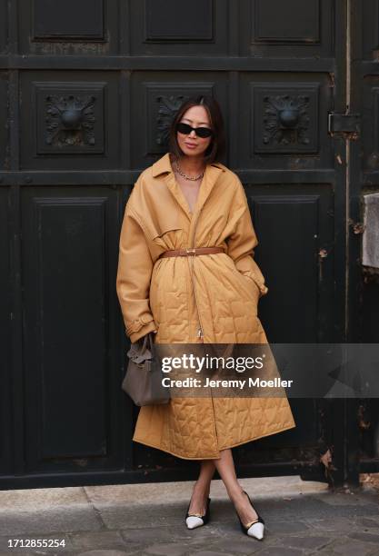 Aimee Song is seen outside Hermes show wearing black sunnies, golden Tiffany hardware collection necklace, camel colored oversized padded coat with...