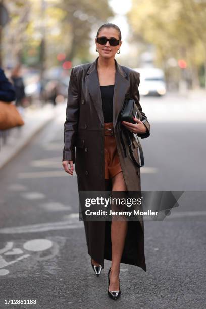 Darja Barannik is seen outside Hermes show wearing brown Celine sunnies, brown long leather coat, black top and brown shorts, black Hermes handbag,...