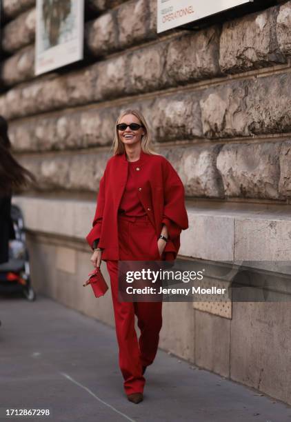 Claire Rose is seen outside Hermes show wearing black round sunnies, red cape jacket with silver buttons, red shirt below, red suit high waist pants,...