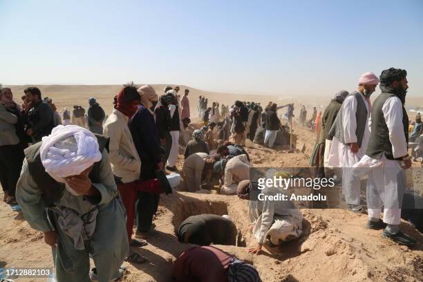Bodies of the deceased are buried after powerful earthquakes destroy buildings and kill over 2000 including children and toddlers, at Kashkak Village...