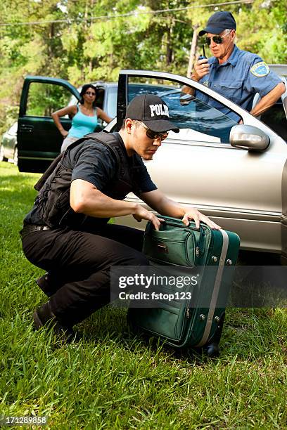 policeman checking woman's luggage during vehicle search - smuggling stock pictures, royalty-free photos & images