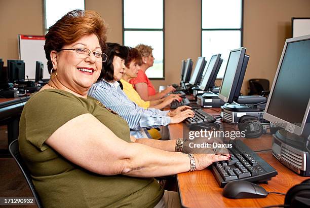 women working in a computer lab - avondschool stockfoto's en -beelden