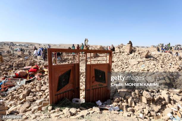 Afghan residents clear debris as they look for victims' bodies in the rubble of damaged houses after the earthquakes in Siah Ab village, Zendeh Jan...