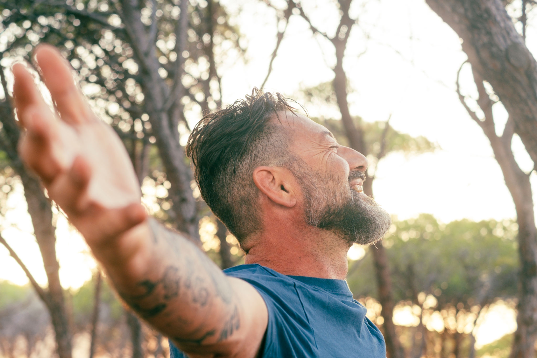 Closeup of side portrait man outstretching arms happy smiling and enjoying sunset light in outdoor nature leisure activity alone. Overjoyed serene expression adult mature male people outside enjoying Closeup of side portrait man outstretching arms happy smiling and enjoying sunset light in outdoor nature leisure activity alone. Overjoyed serene expression adult mature male people outside enjoying