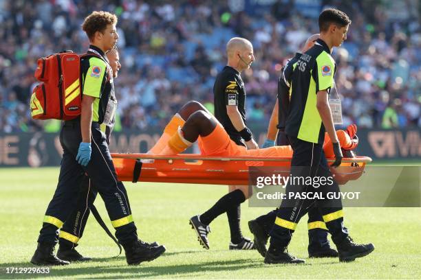Clermont-Ferrand's French goalkeeper Mory Diaw injured by a firecracker, is evacuated on a stretcher during the French L1 football match between...