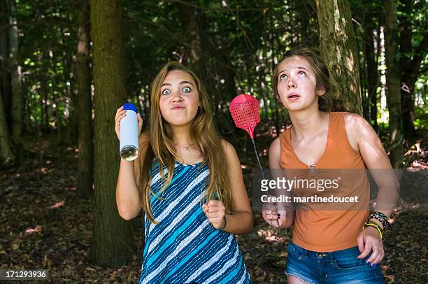 teen girls make faces chasing insects in a forest - mygga bildbanksfoton och bilder