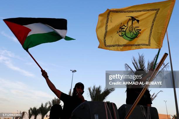 Members Iraq's Shiite Muslim al-Nujaba movement wave the Palestinian flag during a rally in Baghdad on October 8 to express their support of the...