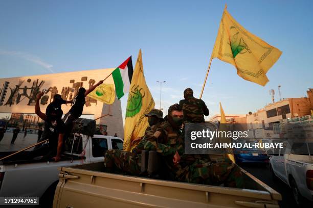 Members of Iraq's Shiite Muslim al-Nujaba movement wave the Palestinian flag during a rally in Baghdad on October 8 to express their support of the...