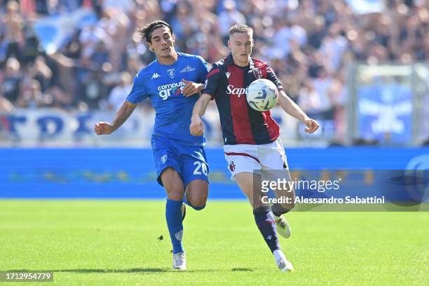 Matteo Cancellieri of Empoli FC competes for the ball with Michel Aebischer of Bologna FC during the Serie A TIM match between Bologna FC and Empoli...