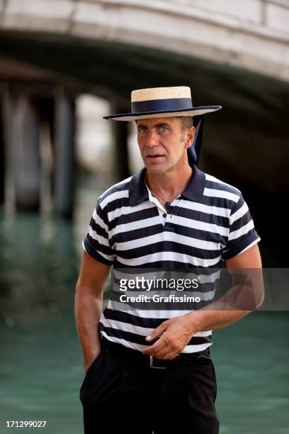 gondolier with hat at canal in venice, italy - gondolier stock pictures, royalty-free photos & images