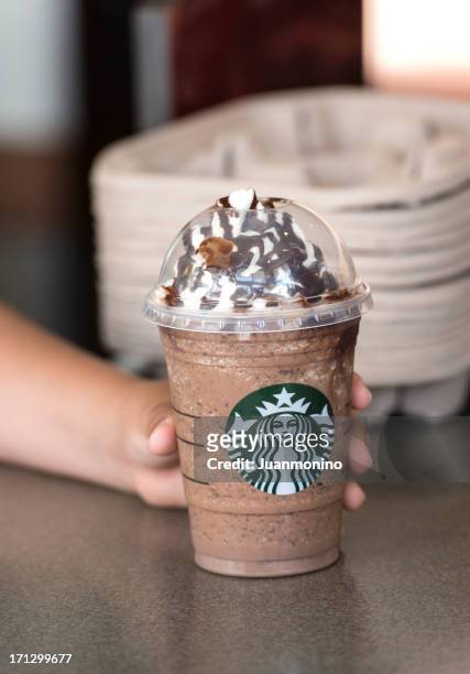 child hand holding a coffee frappuccino - starbucks stockfoto's en -beelden