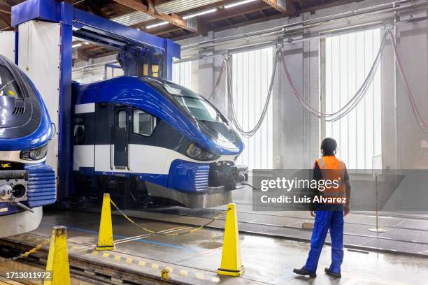 worker watching automatic drive through train washing system in railway workshop - drive through car wash stock pictures, royalty-free photos & images