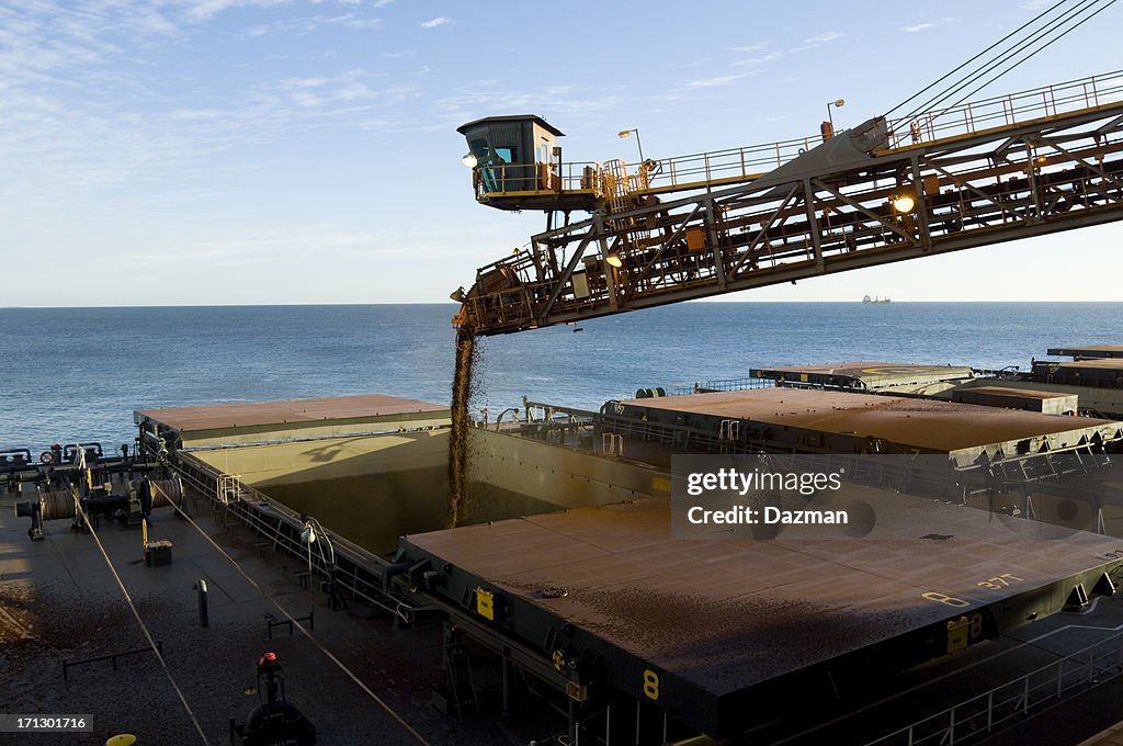Cargo ship being loaded with crushed ore.