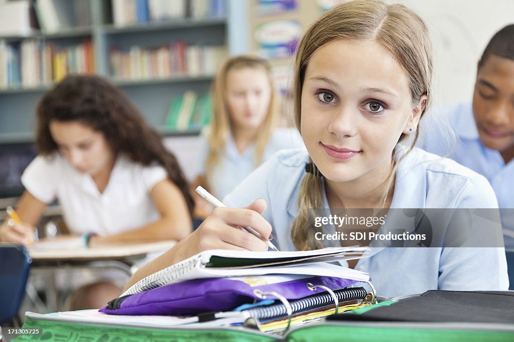 Pretty female student looking up during class