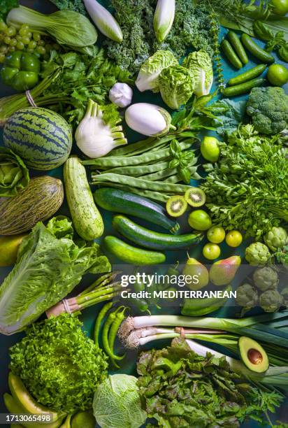 frutta e verdura crude cibo vegano su tavolo verde monocromatico full frame - verdura in foglia foto e immagini stock