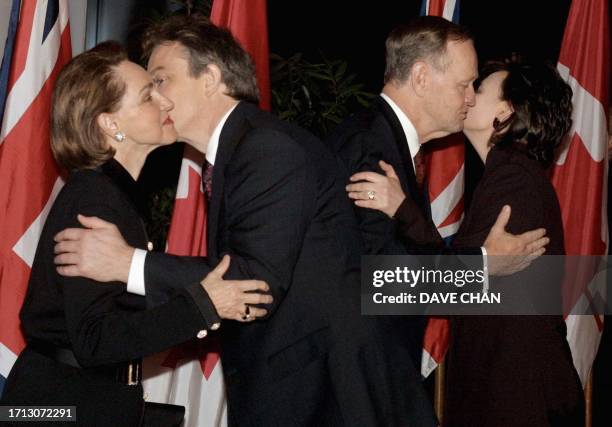 British Prime Minister Tony Blair kisses Aline Chretien , wife of Canadian Prime Minister Jean Chretien , who kisses Cherie Blair, wife of the...