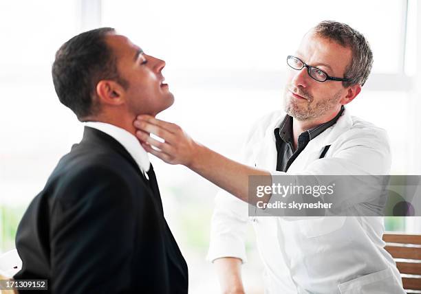 businessman at the doctor's. - thyroid exam stock pictures, royalty-free photos & images