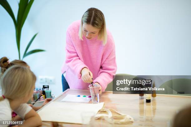 dynamic art instructor kindles passion for acrylic paints within art class - brightly lit classroom stock pictures, royalty-free photos & images