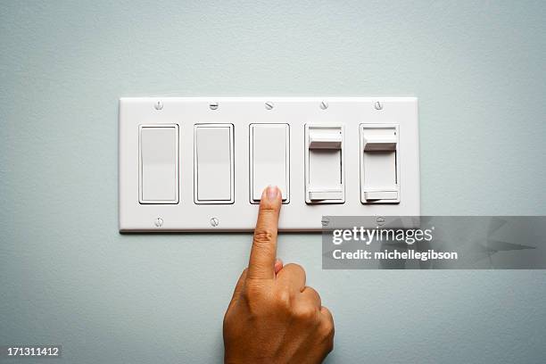 woman's hand turning off the light - electric light stock pictures, royalty-free photos & images