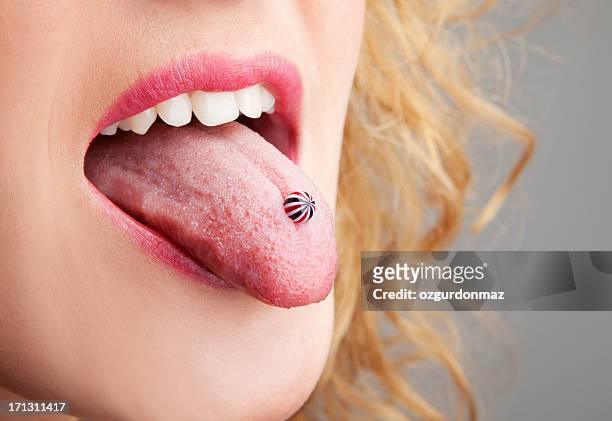 woman has a piercing in the language - body piercings stock pictures, royalty-free photos & images