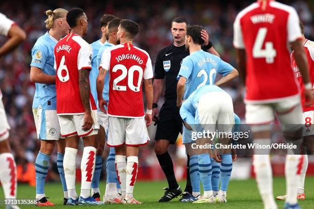Referee Michael Olivier puts his hand on the head of Bernardo Silva of Manchester City during the Premier League match between Arsenal FC and...