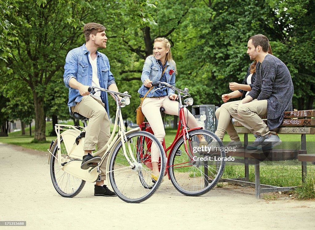 Freunde treffen auf Fahrrädern im park