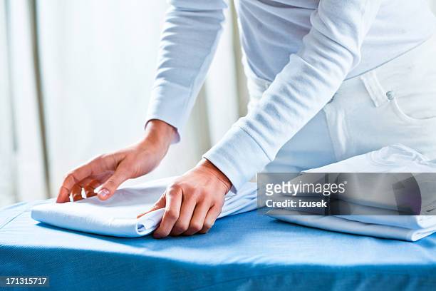 woman stacking ironed folded shirts - 折疊的 個照片及圖片檔