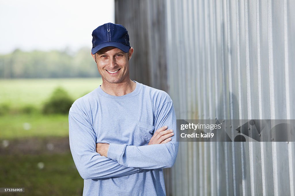 Smiling man in cap standing  outside building