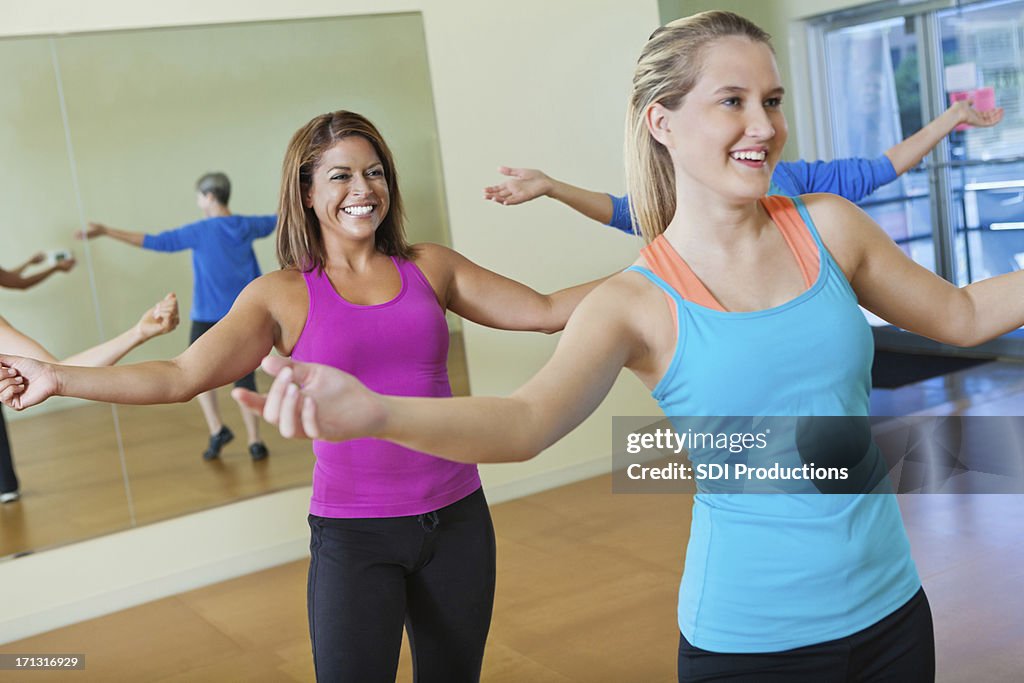 Happy group of women exercising together in fitness class