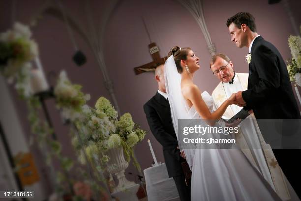 bride and groom couple at the alter during wedding ceremony - wedding ceremony alter stock pictures, royalty-free photos & images