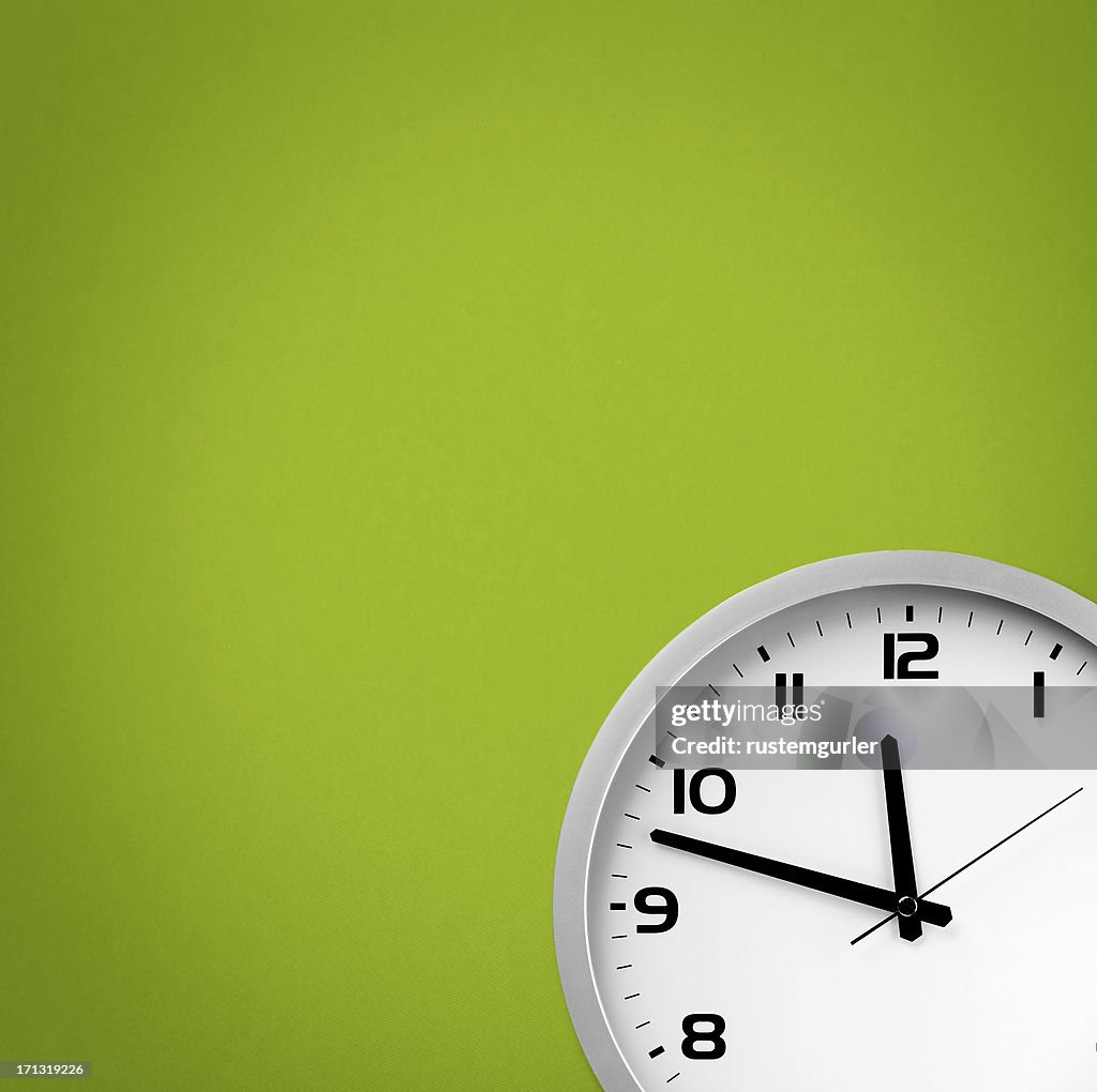 White clock on a green background