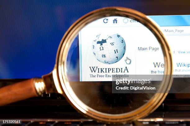 wikipédia site web à travers une loupe - wikipedia photos et images de collection