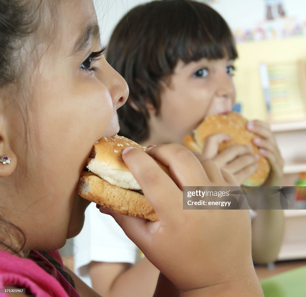 Niño y niña con hamburguesas