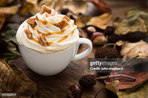 caramel and whipped cream topped coffee with autumn leaves - caramel block stock pictures, royalty-free photos & images