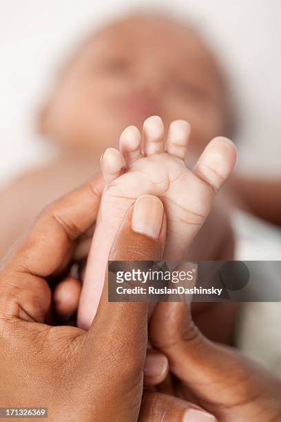 baby foot massage. - black male feet stockfoto's en -beelden