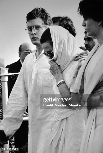 Mourning Sonia Gandhi, widow of former Prime Minister Rajiv Gandhi flanked by son Rahul Gandhi and daughter Priyanka Gandhi walking to the cremation...