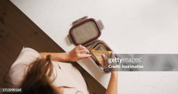 woman packing a lunchbox before going to work - lunchbox stockfoto's en -beelden